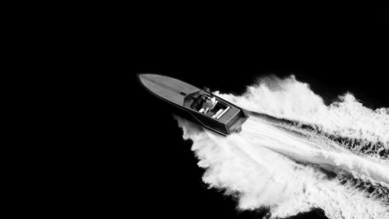 A powerboat at speed carving a white wake across black water